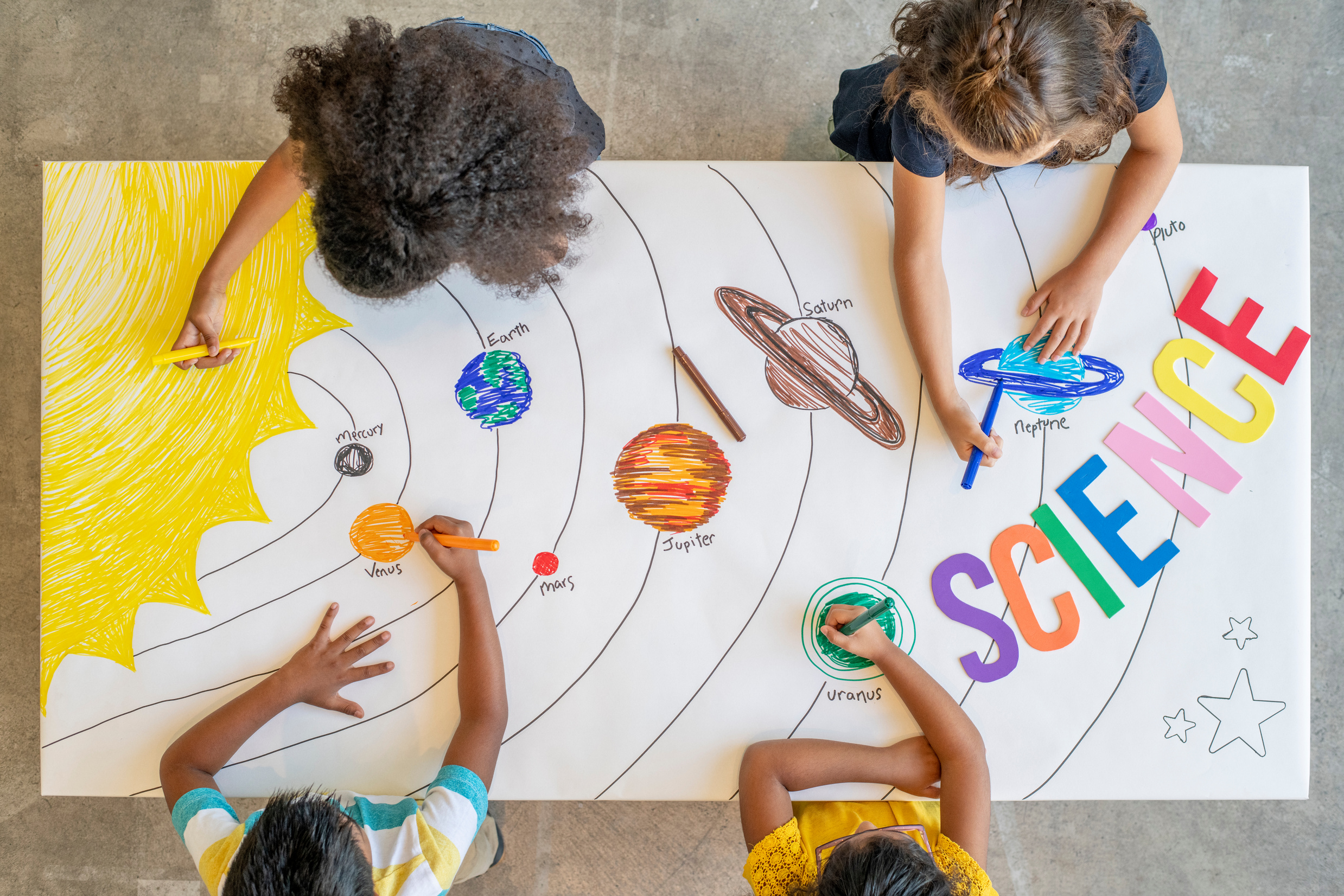 Kids colouring a picture of outer space