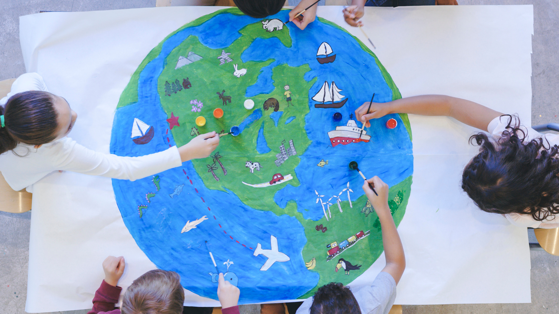 Kids painting mural of the world